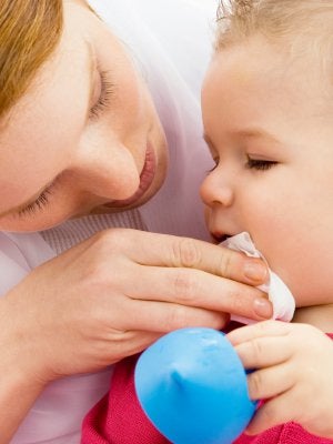 Mother cleaning up baby vomit