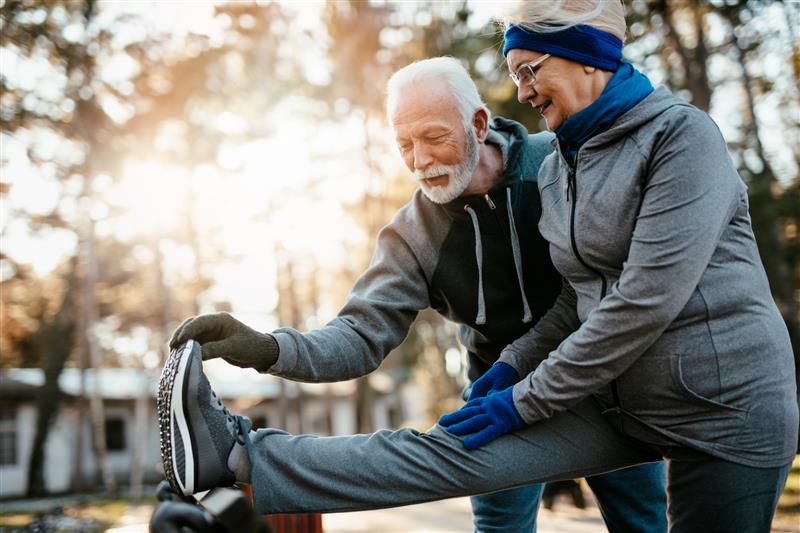 A pair of elderly people stretching