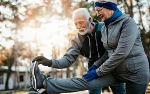A pair of elderly people stretching