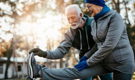 A pair of elderly people stretching